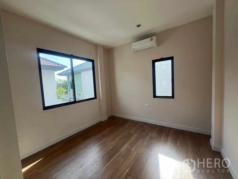 บ้าน ขายในBang Kruai, Nonthaburi - ห้องนอนที่สอง พื้นไม้ เครื่องปรับอากาศติดผนัง และหน้าต่างสองด้านรับลม