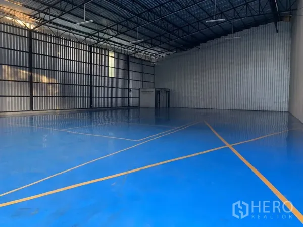 货栈 出租在Khan Na Yao, Bangkok - 仓库内部空间宽敞，钢桁架高挑屋顶，蓝色环氧地坪并有安全标线。