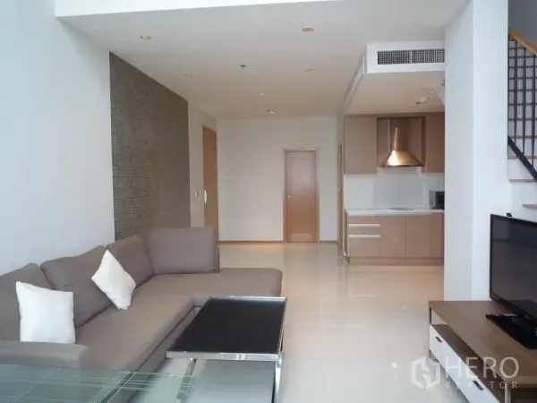 คอนโด ให้เช่าในKhlong Toei, Bangkok - ห้องนั่งเล่นคอนโดดูเพล็กซ์พร้อมโซฟา ทีวี ครัวเปิด และบันได ในเขตคลองเตย กรุงเทพฯ