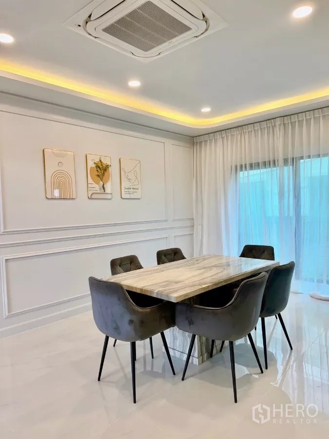 Detached House for rent in Bang Phli, Samut Prakan - Dining room with marble-top table for six, cassette ceiling air-conditioner and sheer curtains.