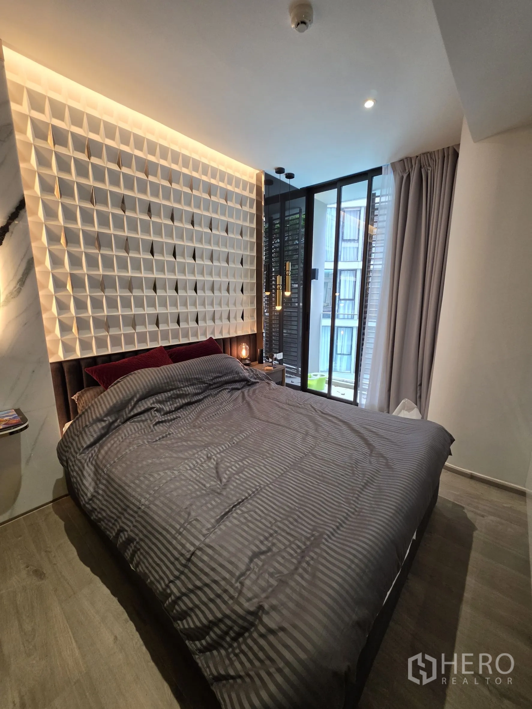 คอนโด for rent in Khlong Toei, Bangkok - ห้องนอนพร้อมเตียงควีน ผนังหัวเตียงลายเรขาคณิต และหน้าต่างบานใหญ่พร้อมผ้าม่าน