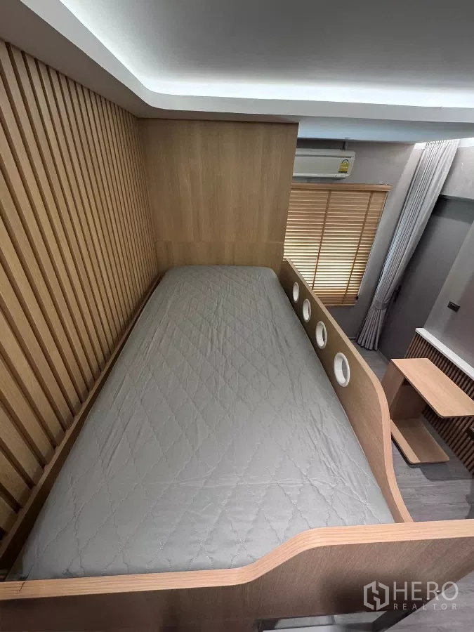 ทาวน์เฮาส์ ให้เช่าหรือขายในLat Phrao, Bangkok - เตียงชั้นบนดีไซน์ช่องกลมและผนังไม้ตีซ้อน