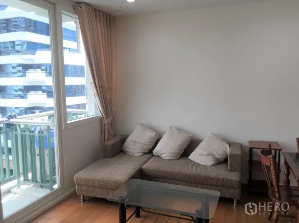 คอนโด ให้เช่าหรือขายในWatthana, Bangkok - มุมนั่งเล่นโซฟาพร้อมโต๊ะกระจก และทางออกสู่ระเบียงขนาดกะทัดรัด