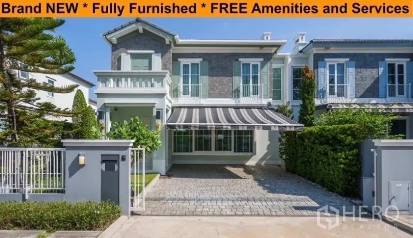 Detached House for rent in Prawet, Bangkok - Two-storey detached house facade in Prawet with paved driveway, striped awning and gated front garden.