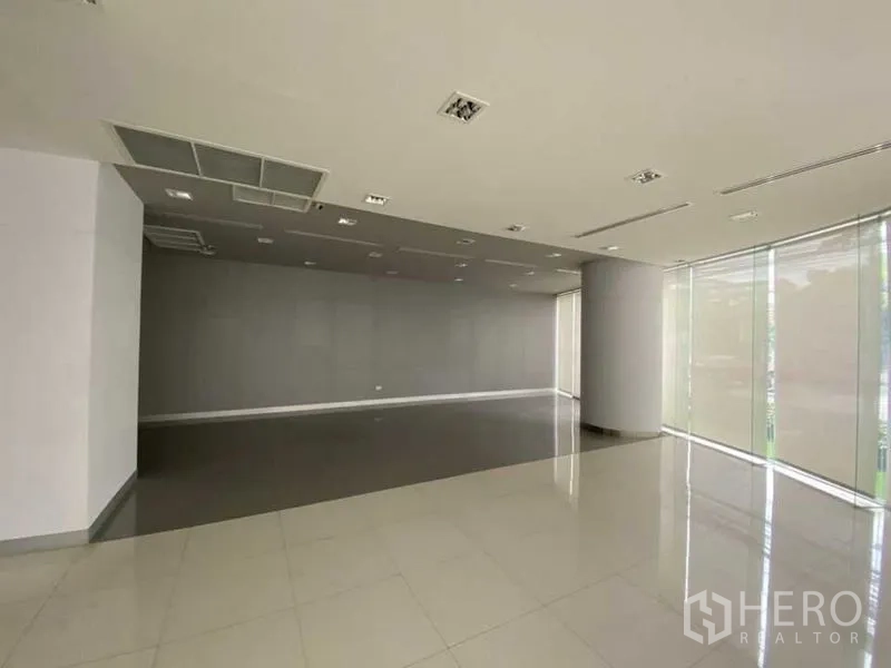 零售空间 出租 - 开放式零售楼层，灰色强调墙与高窗百叶。