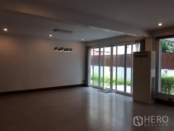 独立式住宅 出租或出售在Khan Na Yao, Bangkok - 宽敞客厅，落地推拉门通向小花园