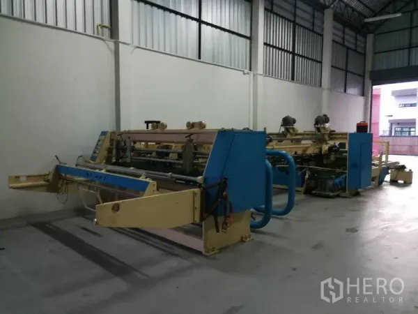 Factory for sale in Bang Len, Nakhon Pathom - Spacious high-ceiling production hall with industrial machinery inside the factory.