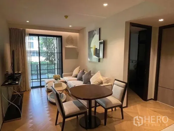 Condominium for rent - Contemporary living and dining area with round table, sofa and sliding doors to a balcony facing greenery.
