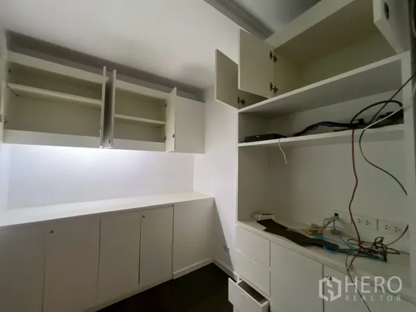 Office Space for rent in Watthana, Bangkok - Storage room with built-in white cupboards and open shelves, ready for office equipment.