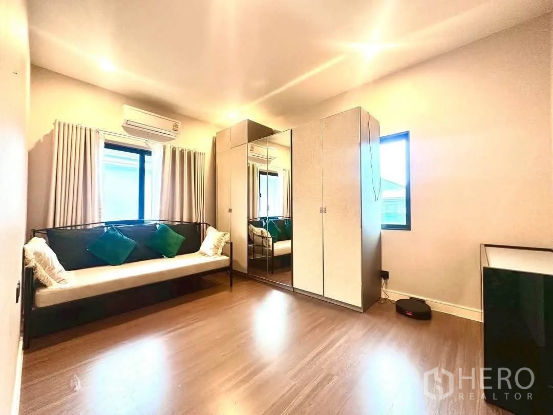 Detached House for rent in Bang Kapi, Bangkok - Cozy bedroom with wood floor, daybed and mirrored wardrobe.