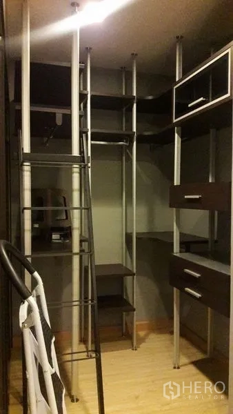 Condominium for rent in Khlong Luang, Pathum Thani - Walk-in closet fitted with modular shelving, drawers and hanging rails.
