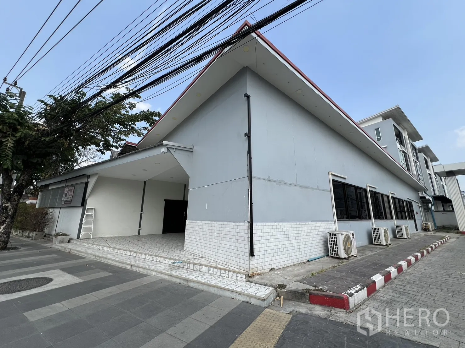 零售空间 for rent in Bueng Kum, Bangkok - 斜角视图显示单层长条商铺，侧窗与室外空调机组一排排列。