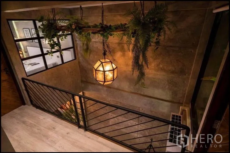 ทาวน์เฮาส์ ให้เช่าในKhlong Toei, Bangkok - โถงบันไดราวเหล็ก โคมไฟเพดานดีไซน์ และไม้ใบห้อยสไตล์ลอฟต์