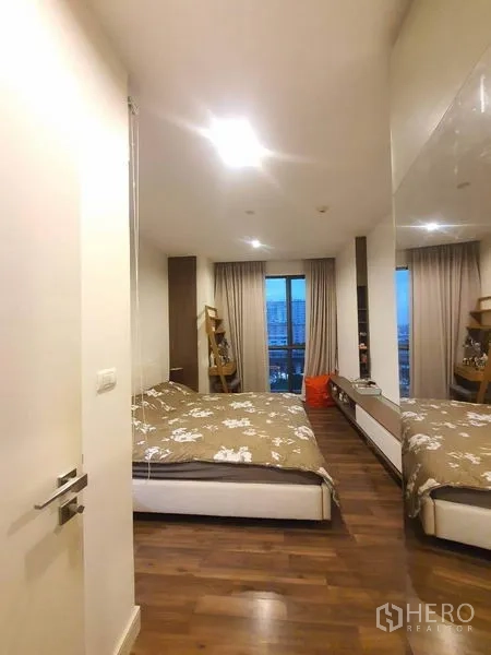 Condominium for sale in Bangkok - Spacious bedroom viewed from the entrance with large window and long built-in shelf.