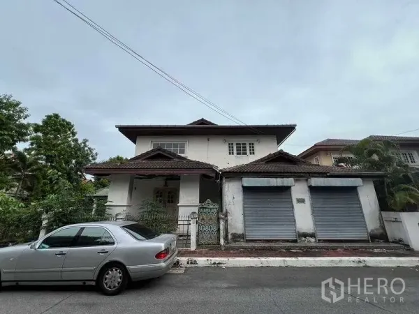 บ้าน ขายในPhra Khanong, Bangkok - บ้านเดี่ยวสองชั้นด้านหน้า ตึกหลังคากระเบื้อง มีประตูรั้วและประตูม้วนคู่ บนซอยเงียบสงบในกรุงเทพฯ