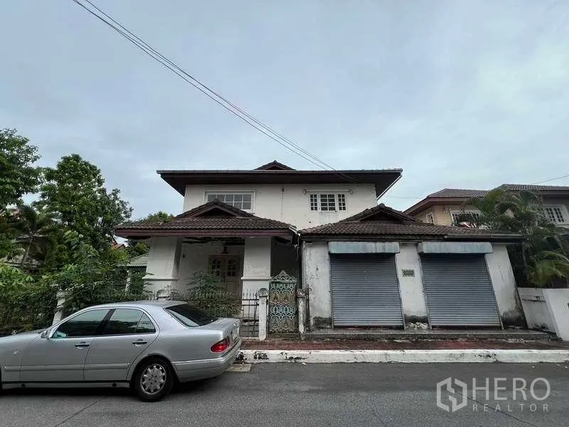 บ้าน ขายในPhra Khanong, Bangkok - บ้านเดี่ยวสองชั้นด้านหน้า ตึกหลังคากระเบื้อง มีประตูรั้วและประตูม้วนคู่ บนซอยเงียบสงบในกรุงเทพฯ