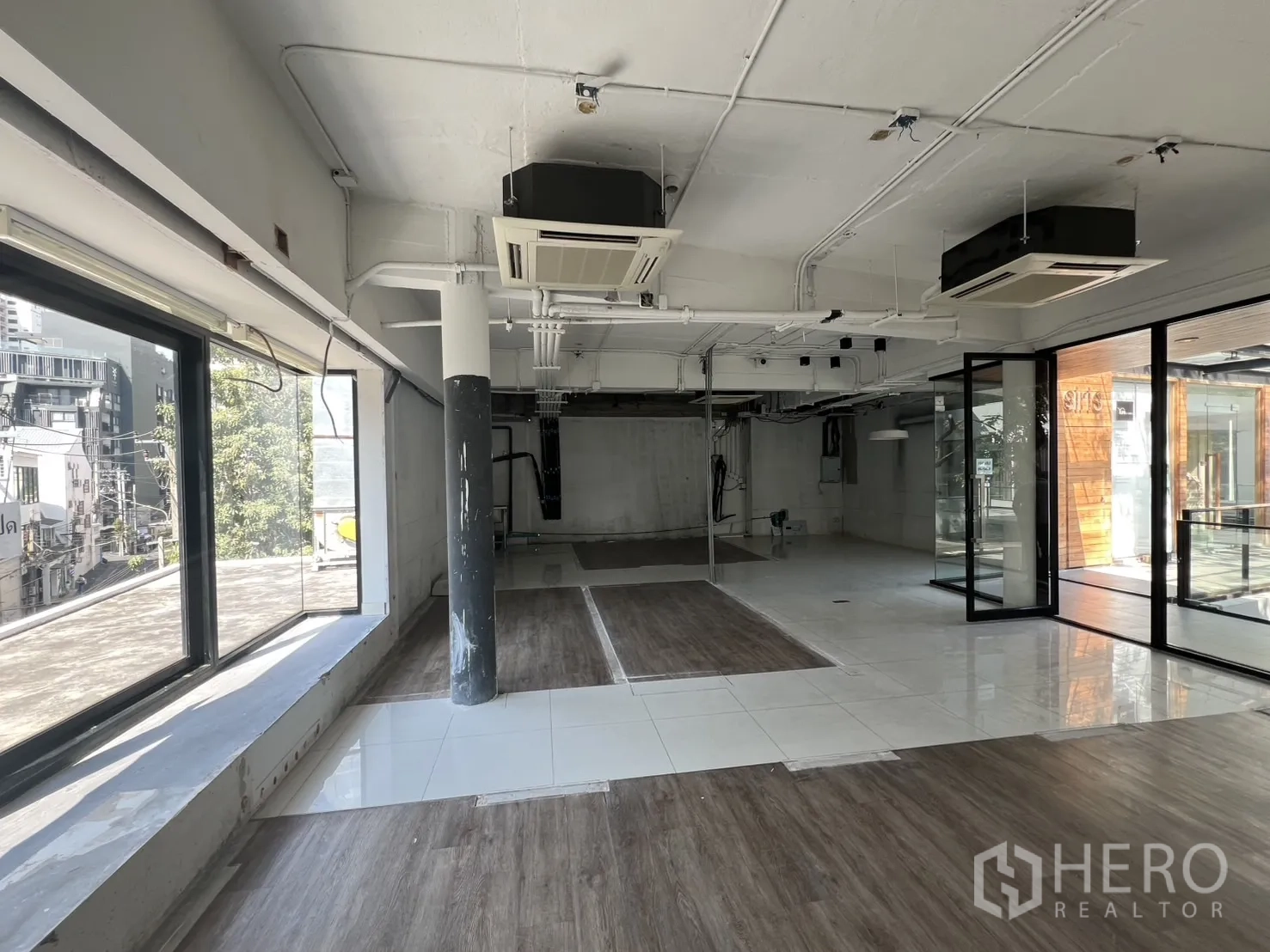 พื้นที่ขายปลีก ให้เช่า - โถงร้านกว้าง พื้นกระเบื้องผสมลามิเนตลายไม้ ประตูกระจก เห็นวิวเมือง