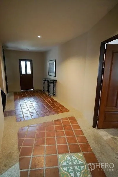 อพาร์ทเมนท์ ให้เช่าในWatthana, Bangkok - โถงทางเดินพื้นกระเบื้องดินเผาพร้อมโต๊ะคอนโซลและประตูไม้