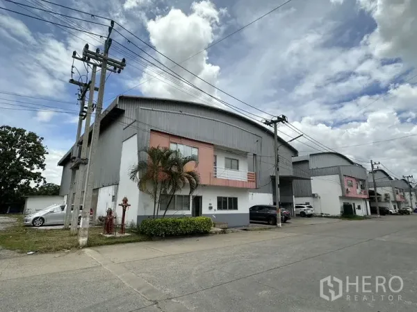 工厂 出租在Phra Nakhon Si Ayutthaya - 工业排屋转角视角，工厂旁有棕榈景观与路边电线杆。