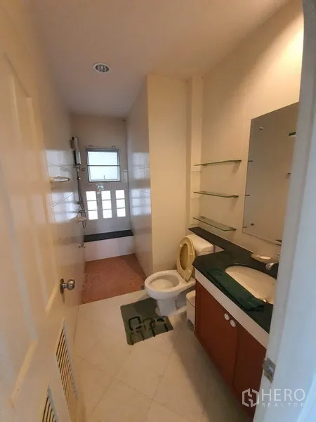 บ้าน ให้เช่าในLat Krabang, Bangkok - ห้องน้ำโทนสว่าง พร้อมอ่างล้างหน้า กระจกชั้นวาง โถสุขภัณฑ์ และส่วนอาบน้ำ.