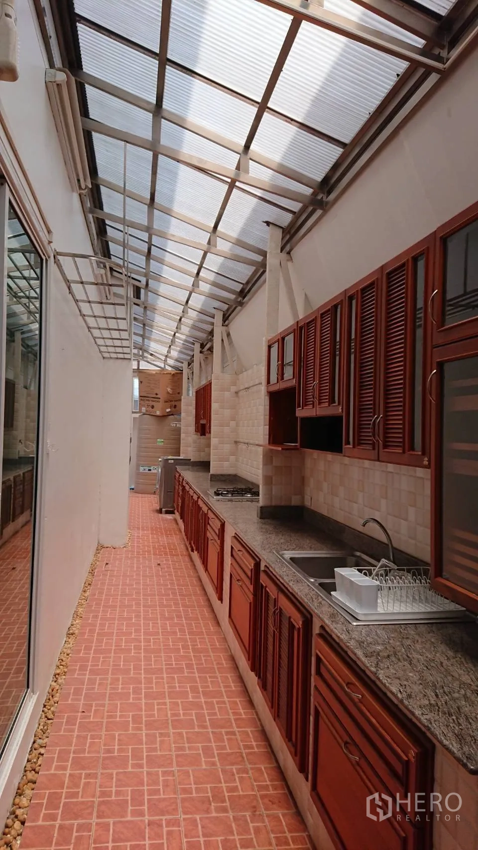 บ้าน ให้เช่าในMueang Samut Prakan, Samut Prakan - ครัวไทยต่อเติม หลังคาโปร่ง เคาน์เตอร์แกรนิตยาว เตาแก๊ส และพื้นกระเบื้องดินเผา