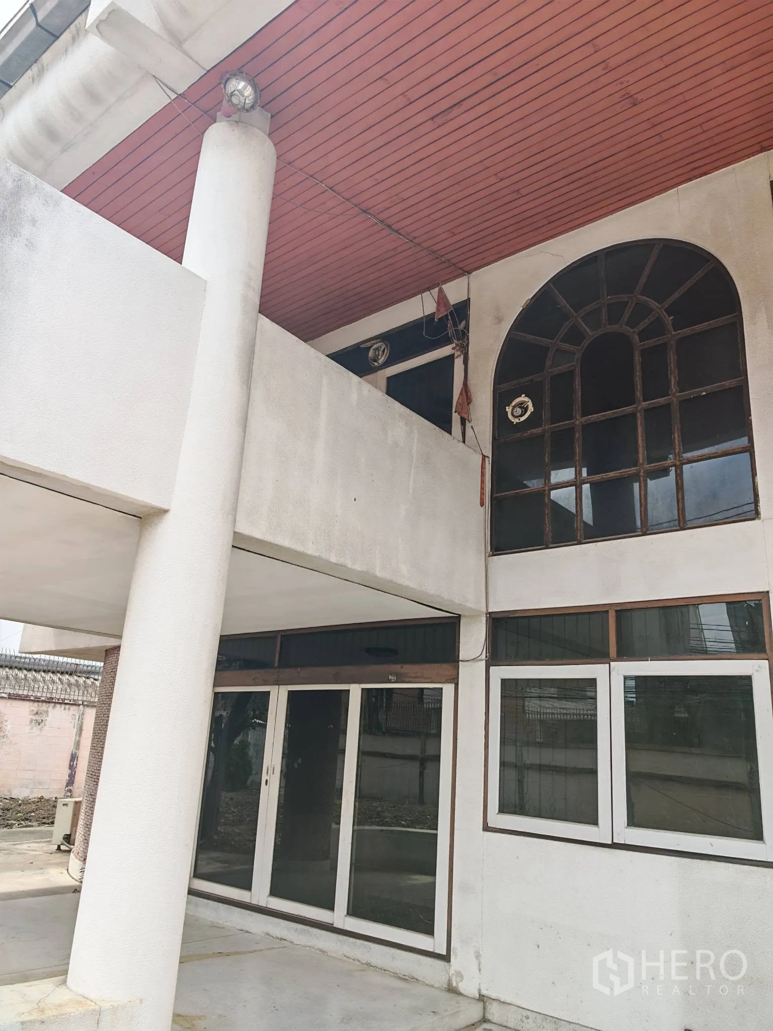 Detached House for rent or sale in Watthana, Bangkok - Front facade with tall column, arched window, and sliding glass doors.