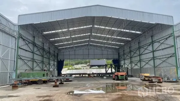 工厂 出售在Nikhom Phatthana, Rayong - 大跨钢结构仓库内部，屋架整齐，空间开阔并配备设备。