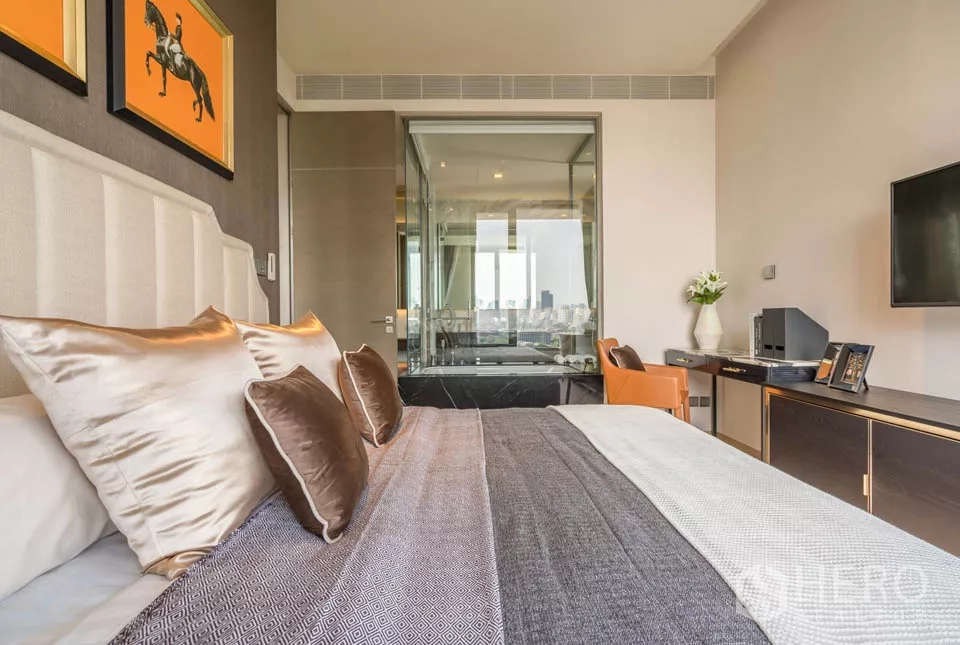 公寓 出租或出售在Bang Rak, Bangkok - 卧室望向玻璃隔断的浴室与书桌，现代感十足。