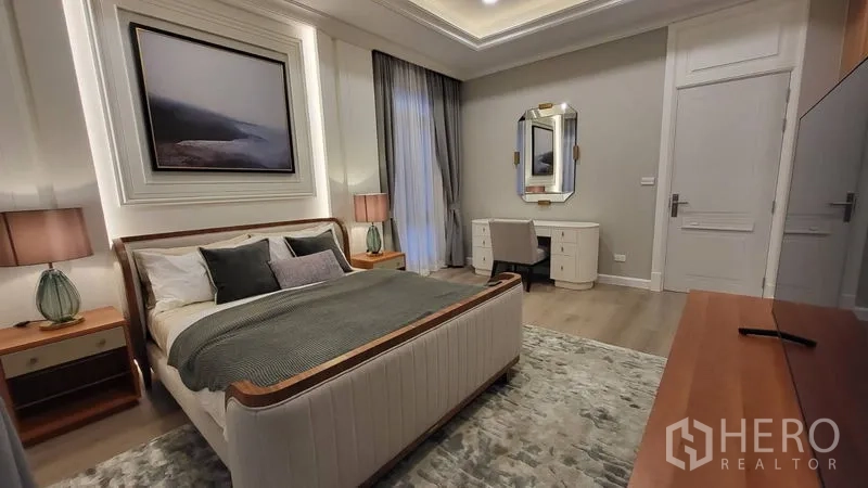 Detached House for rent or sale in Saphan Sung, Bangkok - Guest bedroom with vanity desk, bedside lamps, and neutral décor.