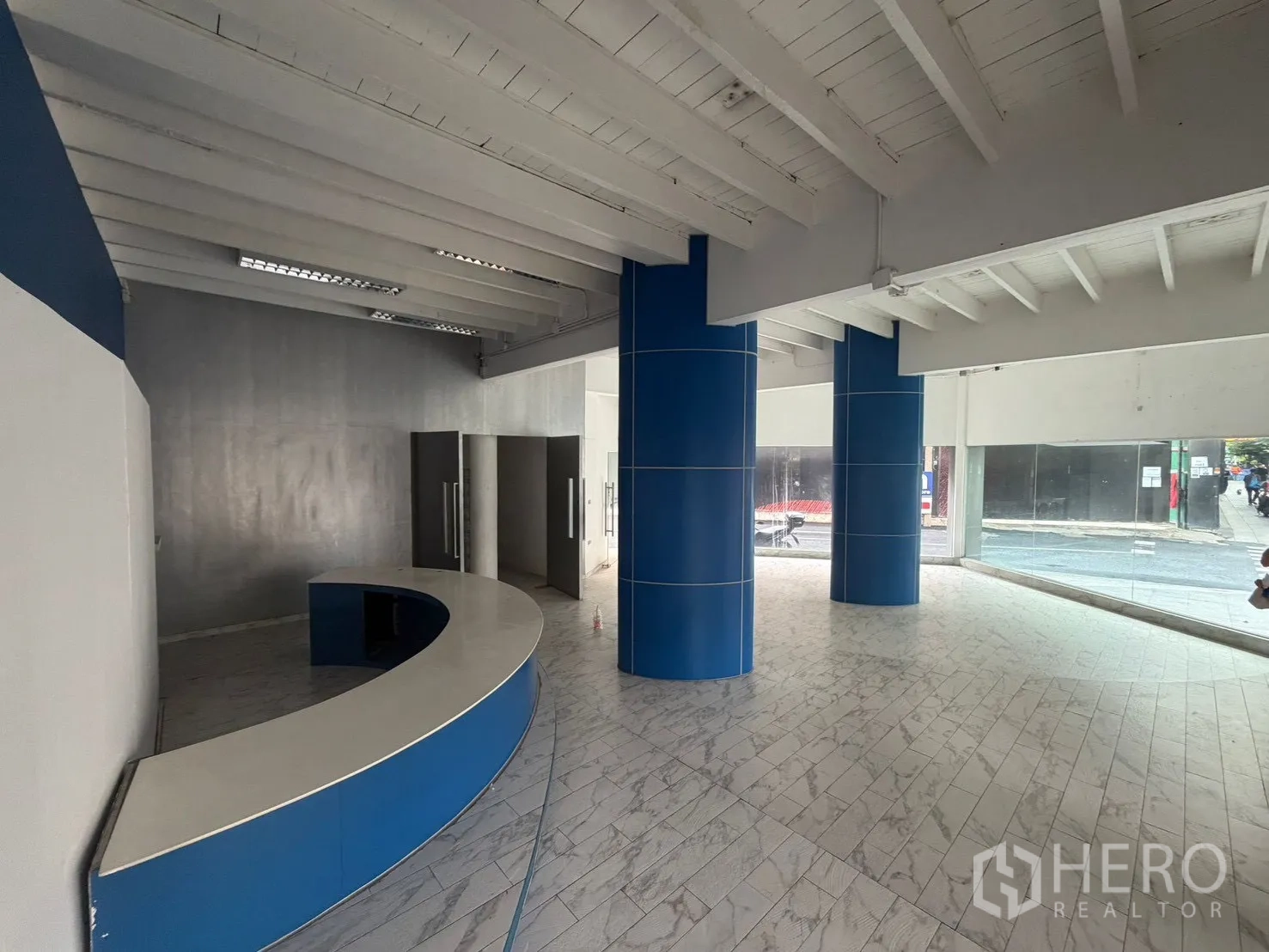 Shophouse for rent in Watthana, Bangkok - Spacious lobby area with a curved reception counter and street-facing glass.
