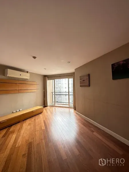 公寓 出租或出售在Yan Nawa, Bangkok - 采光良好的客厅，木地板，壁挂空调，落地门通向阳台与城市景观。