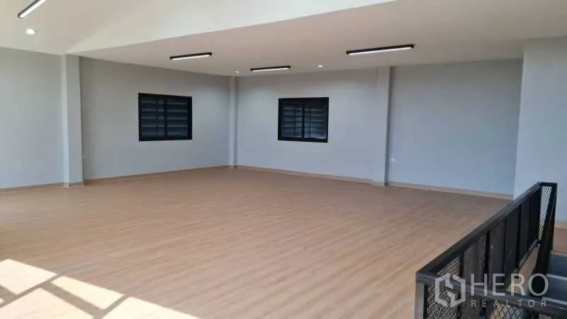 Warehouse for rent in Bang Bua Thong, Nonthaburi - Large mezzanine office area with wood flooring, multiple windows, and LED lighting.