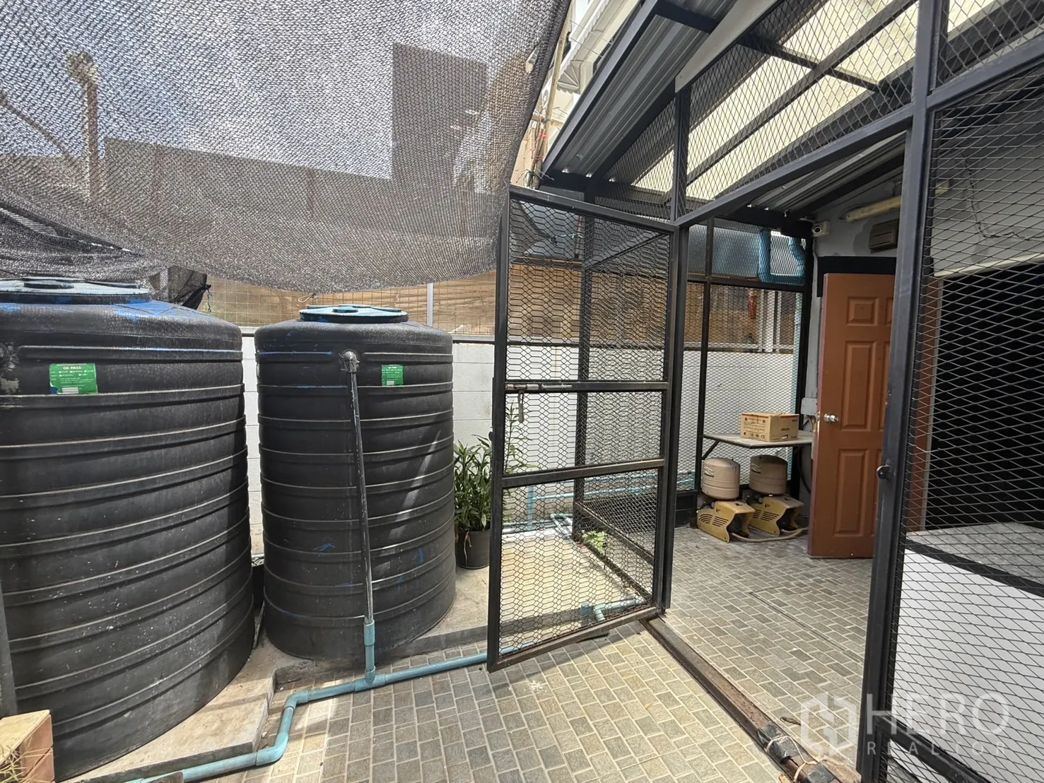 店屋 出租在Wang Thonglang, Bangkok - 后场功能区，配大型蓄水罐与金属网门。