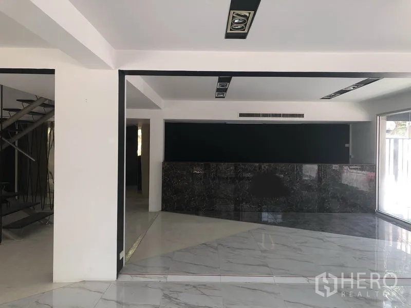 零售空间 出租在Watthana, Bangkok - 宽敞展厅区，带大理石前台、嵌入式照明与大幅展示窗。