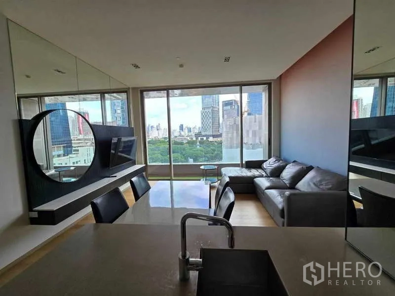 公寓 出租或出售在Bang Rak, Bangkok - 开放式客餐厅，落地窗俯瞰城市与公园天际线，位于 Saladaeng One。