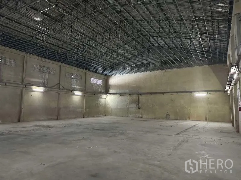 工厂 出租或出售在Bang Phli, Samut Prakan - 仓库空间，高位网格天花，混凝土墙面与明亮灯光。
