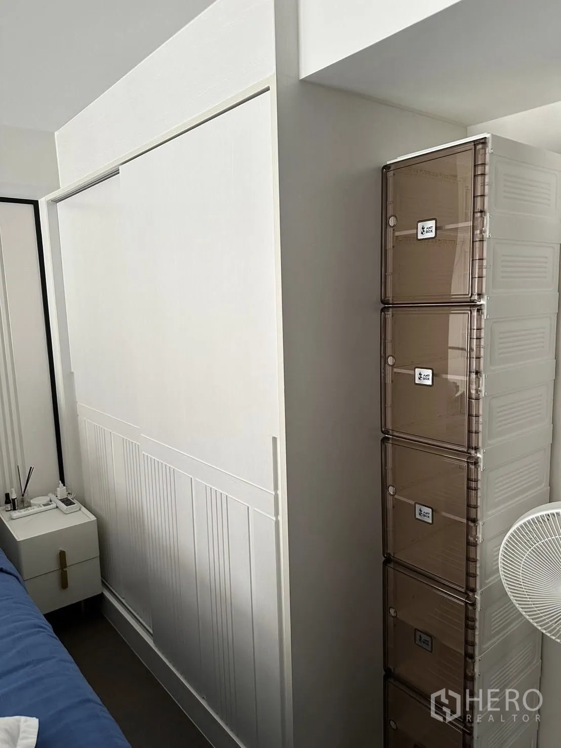 公寓 出租在Bang Rak, Bangkok - 卧室墙面配推拉衣柜门与叠放收纳箱，旁有床头柜。