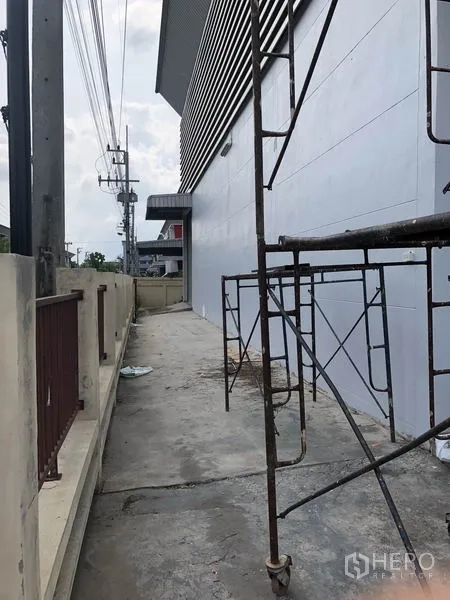 货栈 出租或出售在Lam Luk Ka, Pathum Thani - 仓库侧外走道，有脚手架与围墙。
