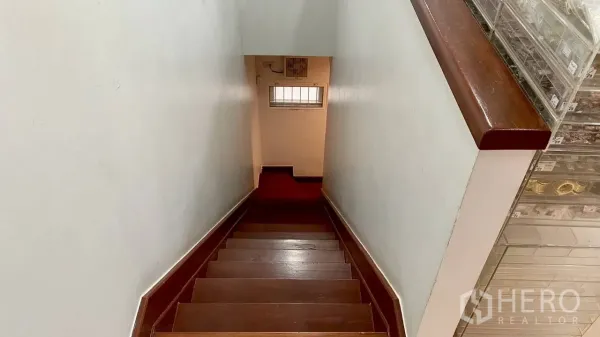 零售空间 出租在Samphanthawong, Bangkok - 木质楼梯通向下层，白色墙面与小窗。