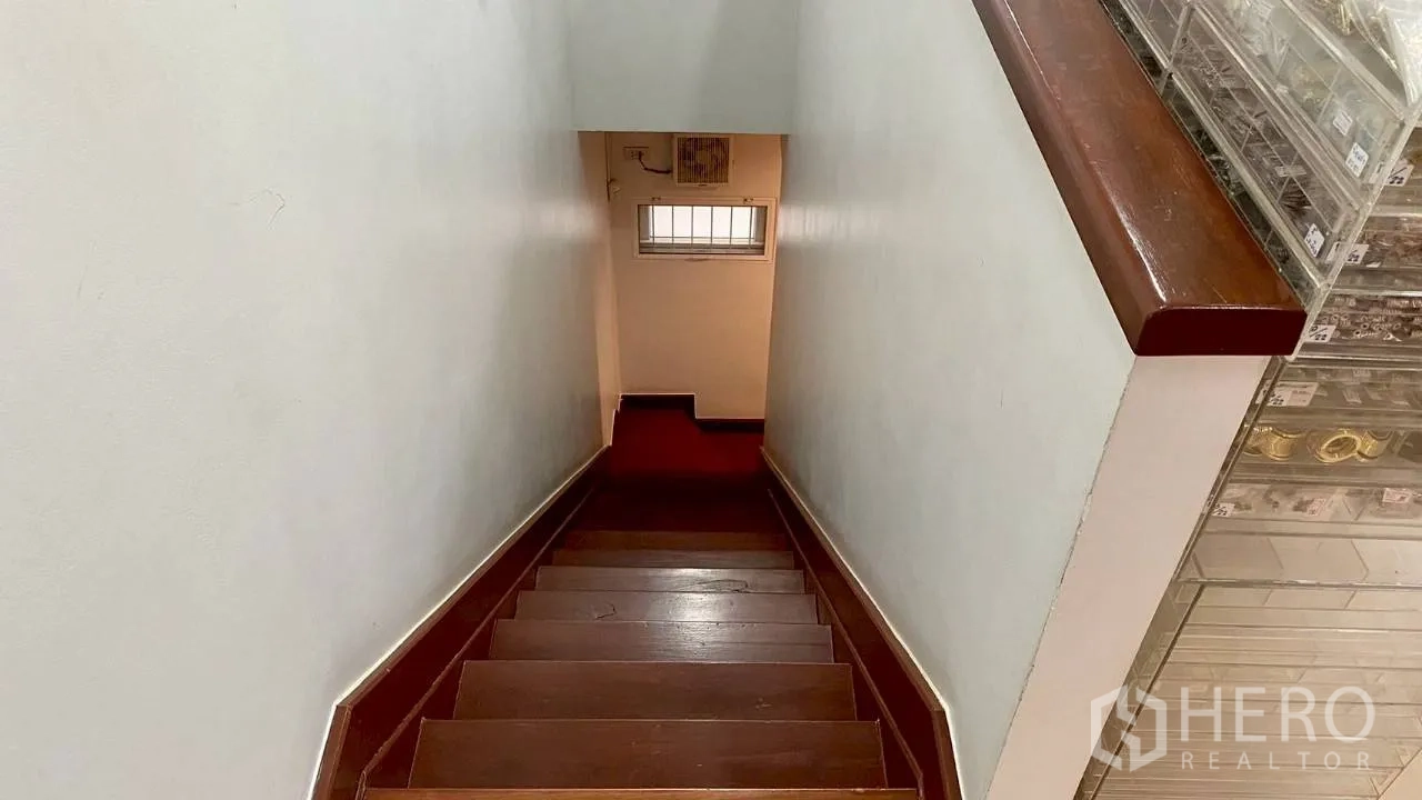 零售空间 出租在Samphanthawong, Bangkok - 木质楼梯通向下层，白色墙面与小窗。