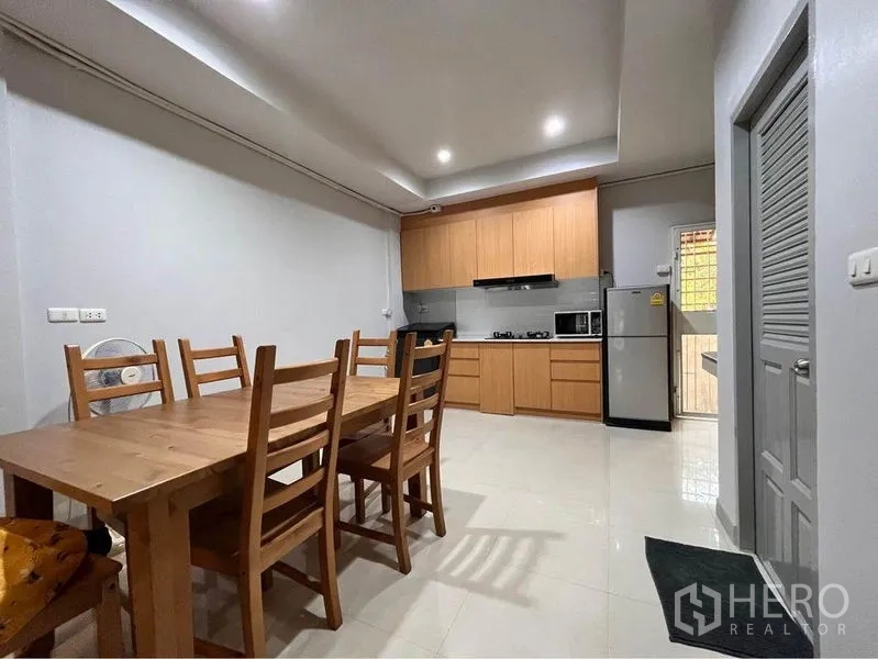 ทาวน์เฮาส์ ให้เช่าในKhlong Toei, Bangkok - มุมรับประทานอาหารพร้อมโต๊ะไม้และเก้าอี้ ติดกับครัวแบบเปิด