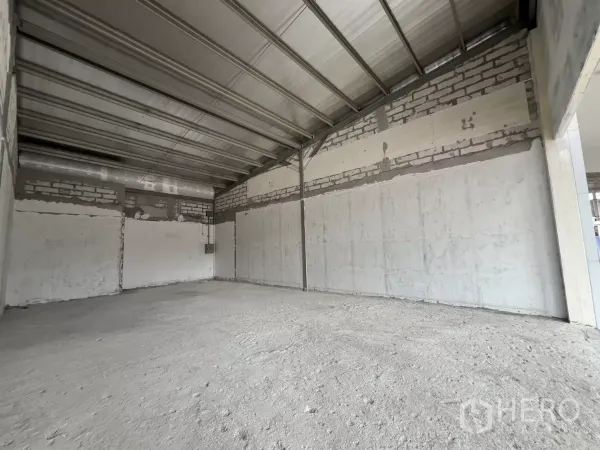 零售空间 出租在Watthana, Bangkok - 长方形店铺内部，裸露砌块墙与未完成的混凝土地面。