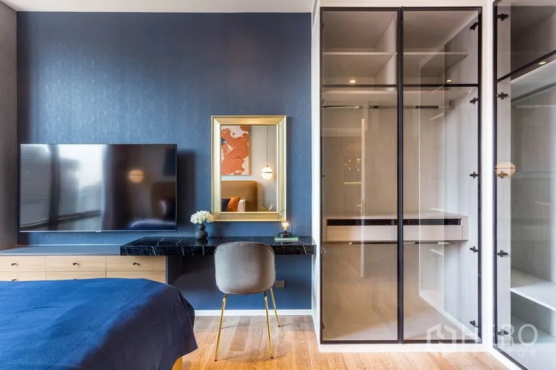 คอนโด ให้เช่าหรือขายในPathum Wan, Bangkok - มุมห้องนอนพร้อมทีวีแขวนผนัง โต๊ะเครื่องแป้ง และตู้เสื้อผ้าบานกระจก ในคอนโดย่านปทุมวัน กรุงเทพฯ