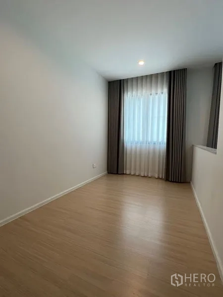 Townhouse for rent in Suan Luang, Bangkok - Spare room with wood-look flooring, recessed lighting and a curtained window.