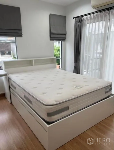 独立式住宅 出租在Suan Luang, Bangkok - 次卧，带收纳功能的白色床与转角窗