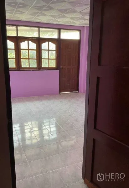Warehouse for rent in Sai Noi, Nonthaburi - Office room with purple walls, large windows, tiled floor, and a wooden door.