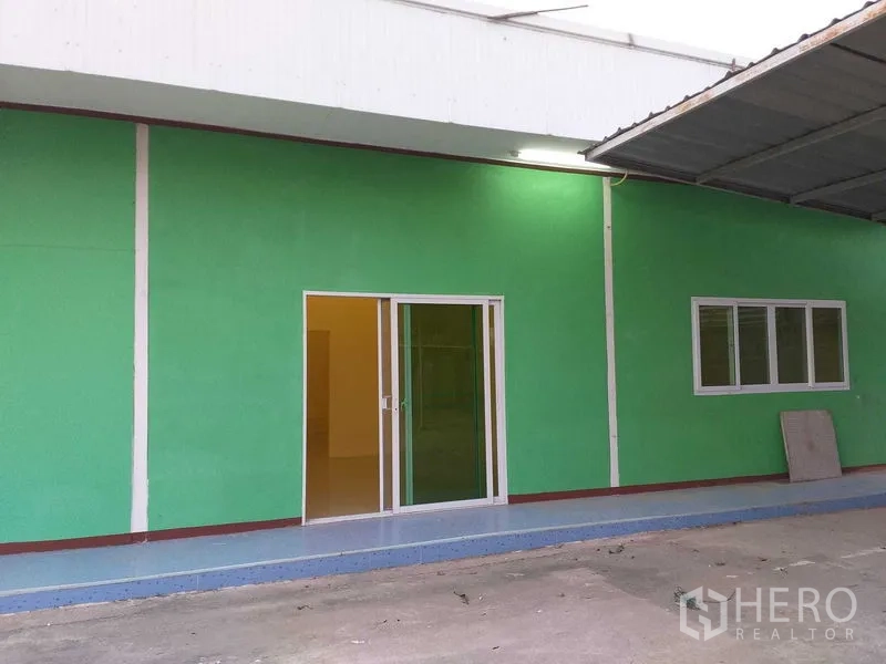 คลังสินค้า ให้เช่าในKhlong Sam Wa, Bangkok - ด้านหน้าอาคารสำนักงานสีเขียว ประตูกระจกบานเลื่อนและหน้าต่างใต้กันสาด