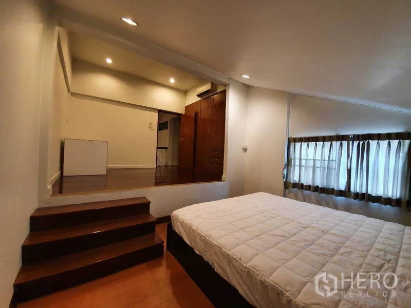 独立式住宅 出租在Phra Khanong, Bangkok - 半层卧室，几级台阶通向衣柜区，窗配窗帘。