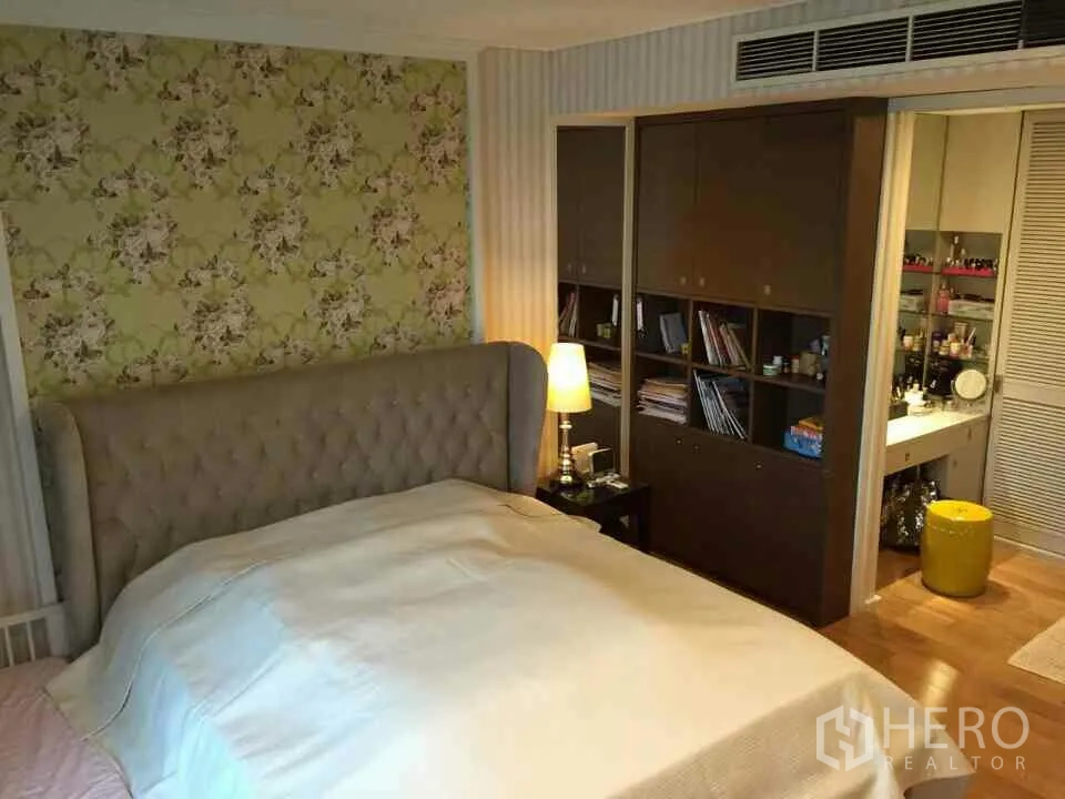 คอนโด ให้เช่าหรือขายในWatthana, Bangkok - ห้องนอนหลักหัวเตียงบุผ้า ผนังลายดอกไม้ ตู้เก็บของบิลด์อิน เชื่อมต่อมุมโต๊ะเครื่องแป้ง