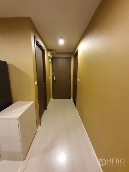 公寓 出租在Sathon, Bangkok - 走廊铺浅色木地板，灯光明亮，通向多扇房门与入户门。